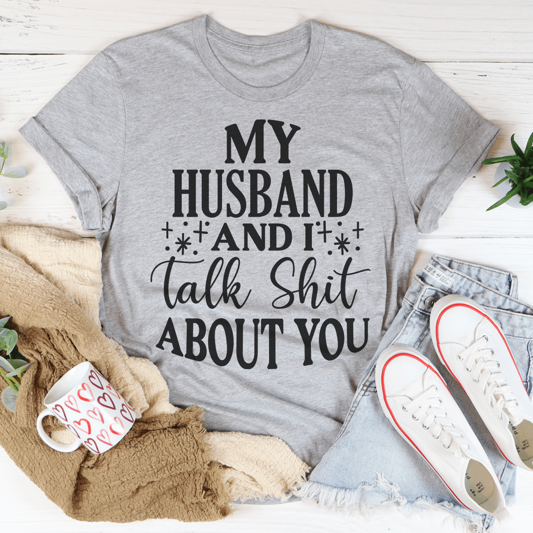 A humorous t-shirt featuring the phrase 'My Husband And I Talk Crap About You', made from soft cotton with double stitching.