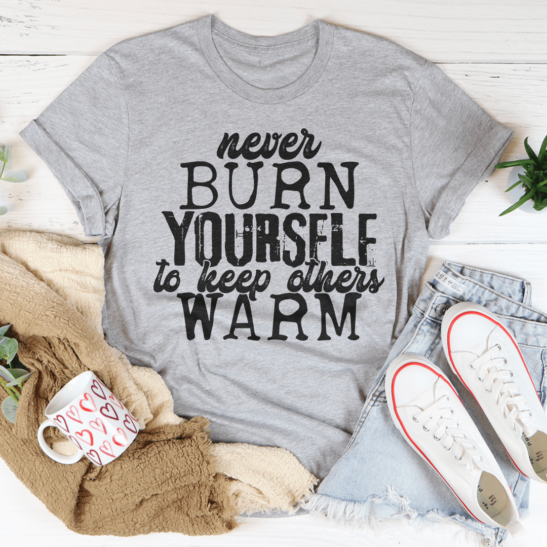 A cozy and stylish Never Burn Yourself To Keep Others Warm Tee made from soft ring-spun cotton, featuring double stitching for durability.