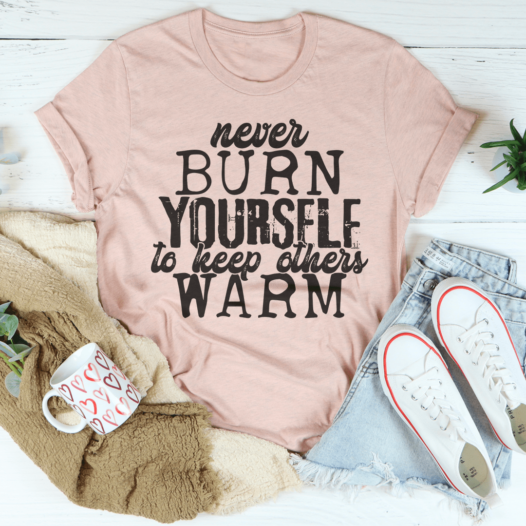 A cozy and stylish Never Burn Yourself To Keep Others Warm Tee made from soft ring-spun cotton, featuring double stitching for durability.