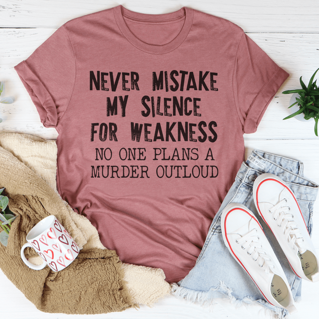 A stylish black t-shirt with the phrase 'Never Mistake My Silence For Weakness' printed in bold letters, showcasing its soft fabric and durable stitching.