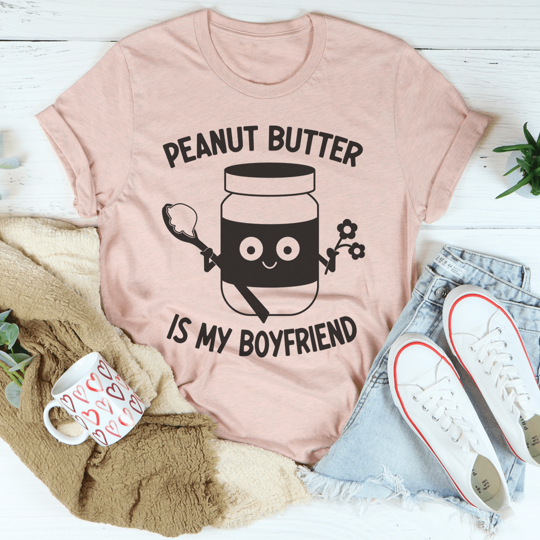 A soft, comfortable t-shirt featuring the phrase 'Peanut Butter Is My Boyfriend' in a playful font, perfect for casual wear.