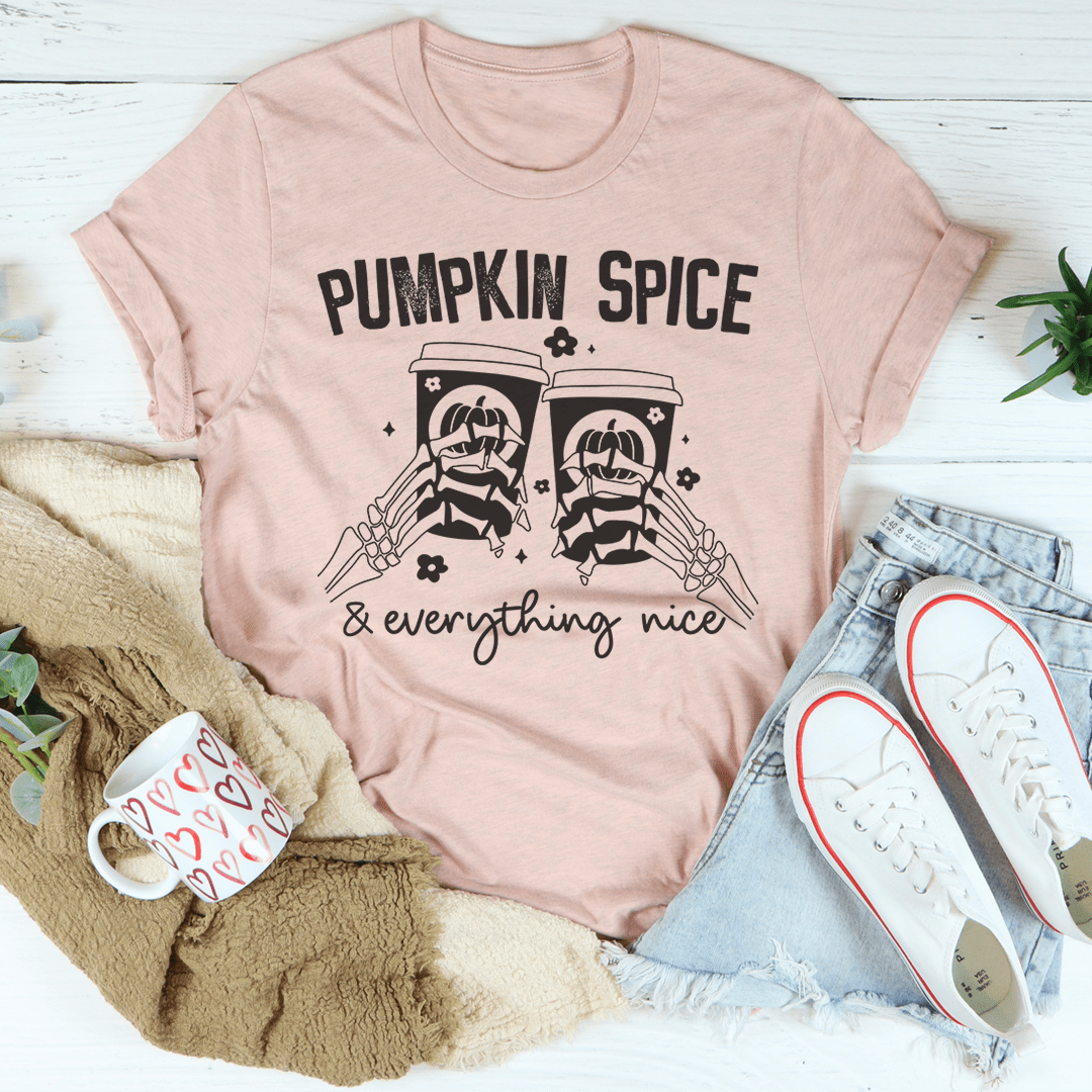 Pumpkin Spice & Everything Nice T-Shirt displayed on a wooden background, showcasing its soft fabric and vibrant autumn-themed design.