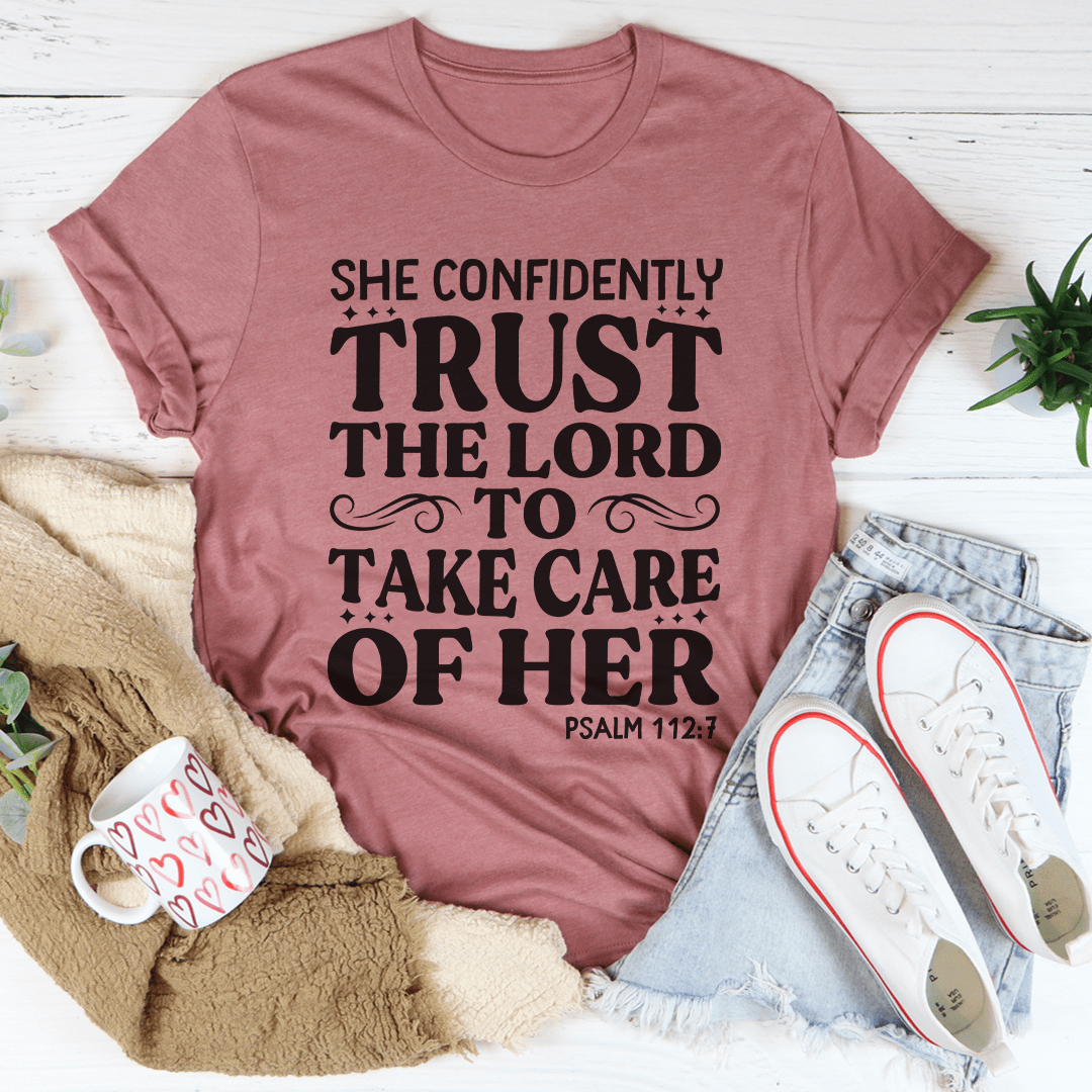 A stylish t-shirt featuring the phrase 'She Confidently Trust The Lord To Take Care Of Her', made from soft cotton with durable stitching.