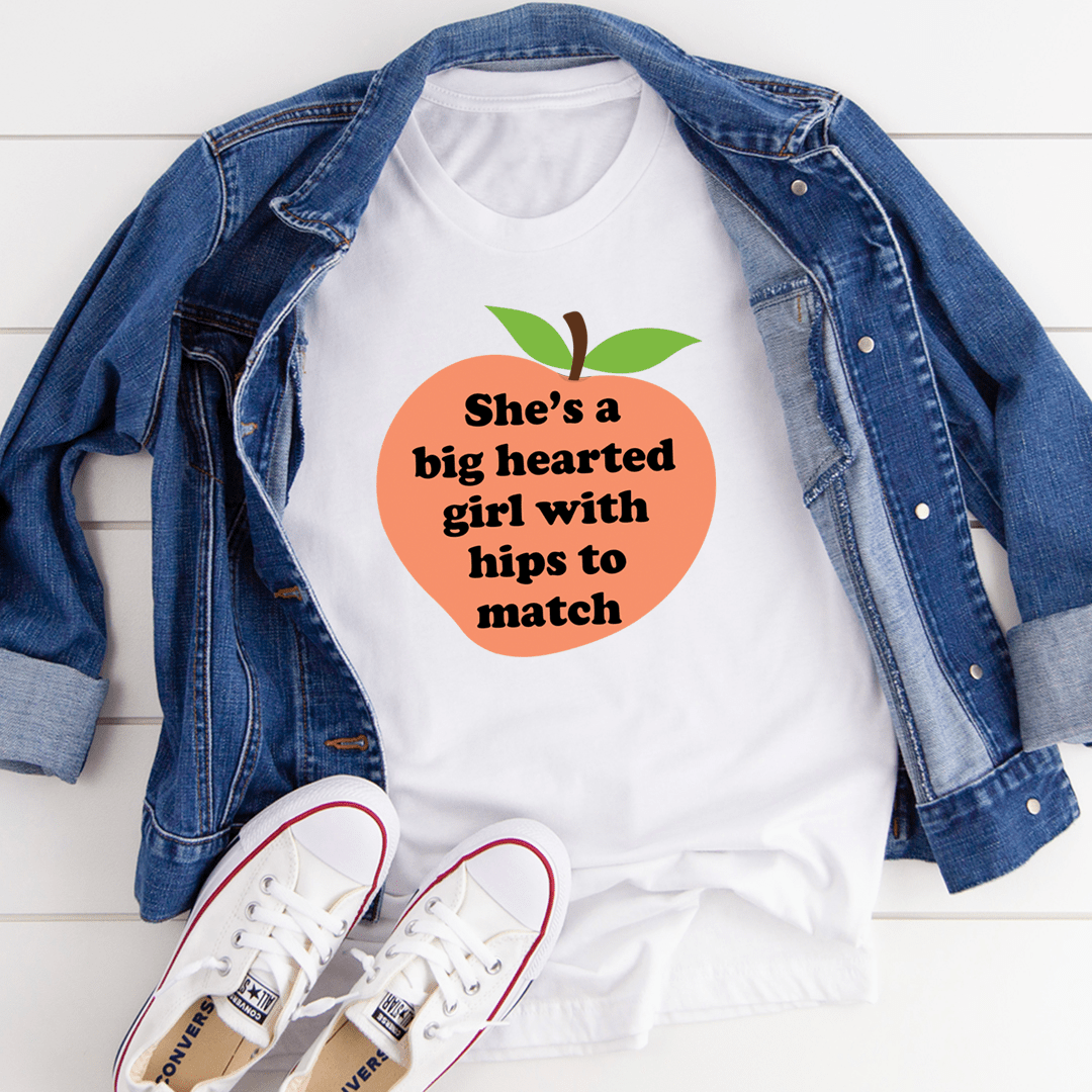 A stylish t-shirt featuring the phrase 'She's A Big Hearted Girl With Hips to Match', made from soft cotton with durable stitching.