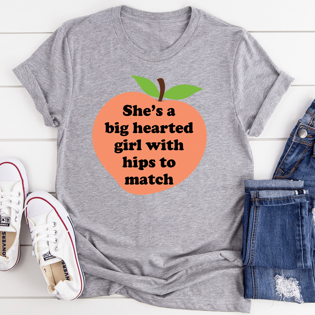 A stylish t-shirt featuring the phrase 'She's A Big Hearted Girl With Hips to Match', made from soft cotton with durable stitching.