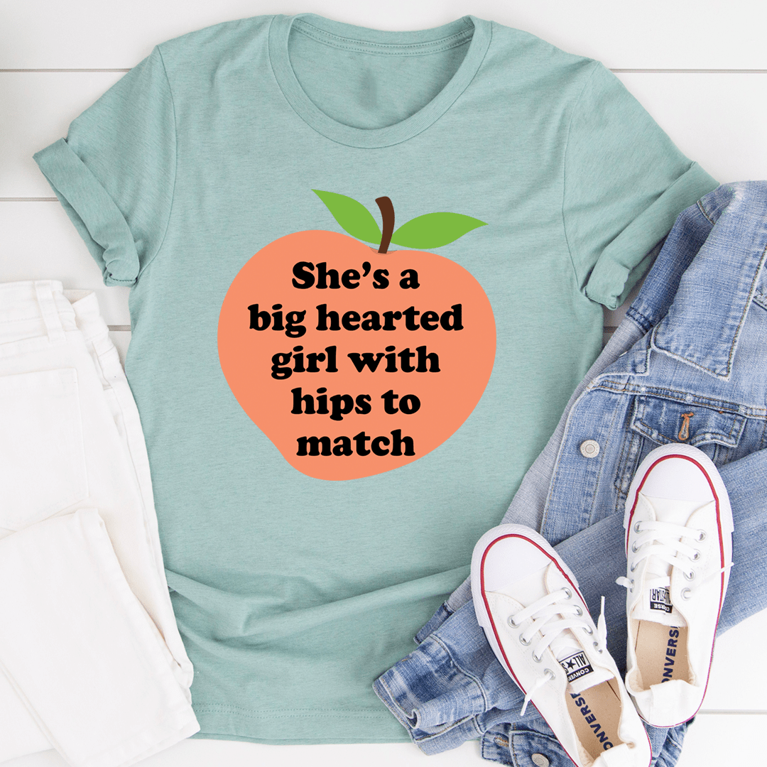 A stylish t-shirt featuring the phrase 'She's A Big Hearted Girl With Hips to Match', made from soft cotton with durable stitching.