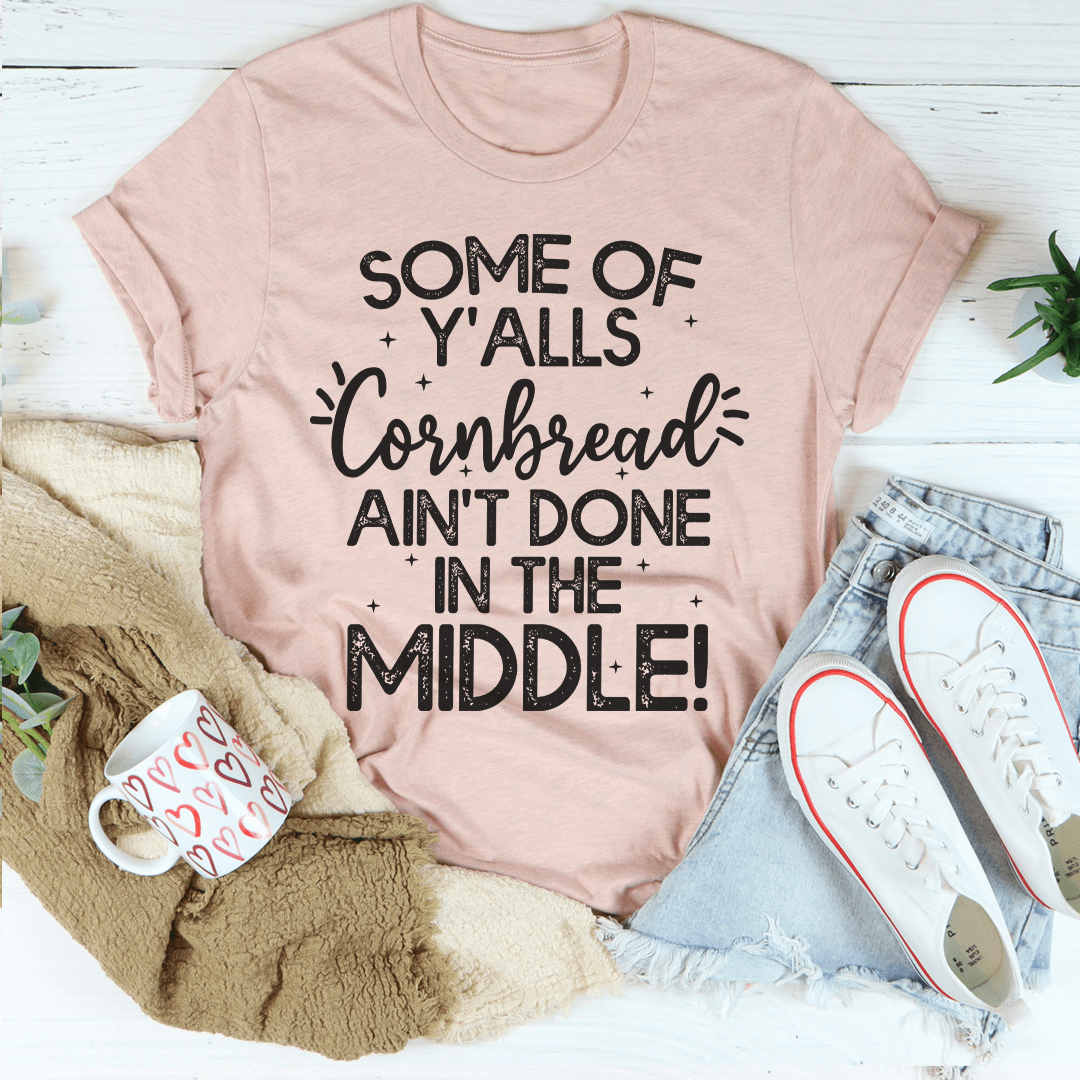 A comfortable and stylish t-shirt featuring the phrase 'Some Of Y'Alls Cornbread Ain't Done In The Middle' printed on it, showcasing its soft fabric and durable stitching.