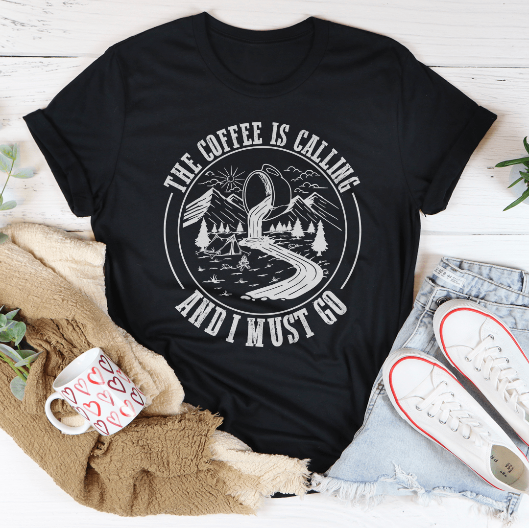 A stylish t-shirt featuring the phrase 'The Coffee Is Calling And I Must Go', made from soft ring-spun cotton with double stitching for durability.