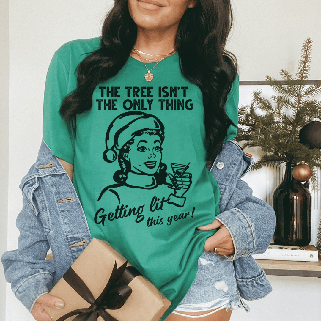 A festive t-shirt featuring the phrase 'The Tree Isn't The Only One Getting Lit This Year', made from soft cotton with double stitching.