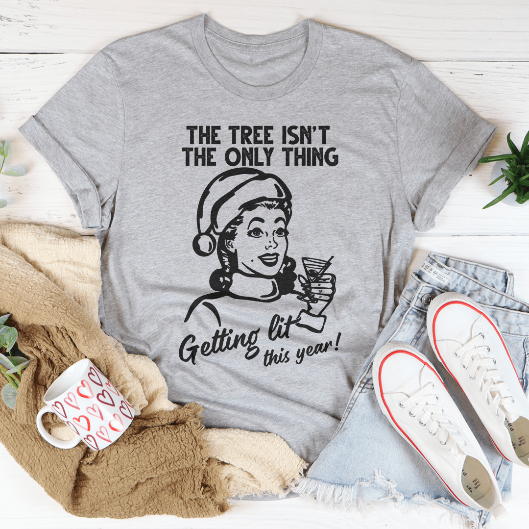 A festive t-shirt featuring the phrase 'The Tree Isn't The Only One Getting Lit This Year', made from soft cotton with double stitching.