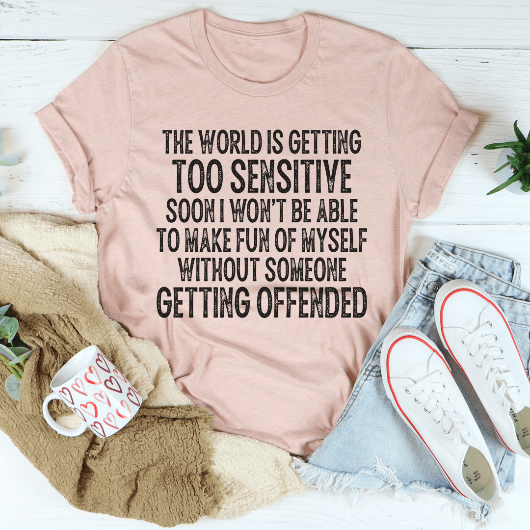 A stylish t-shirt featuring the phrase 'The World Is Getting Too Sensitive' printed on soft ring-spun cotton fabric, showcasing its durability and comfort.