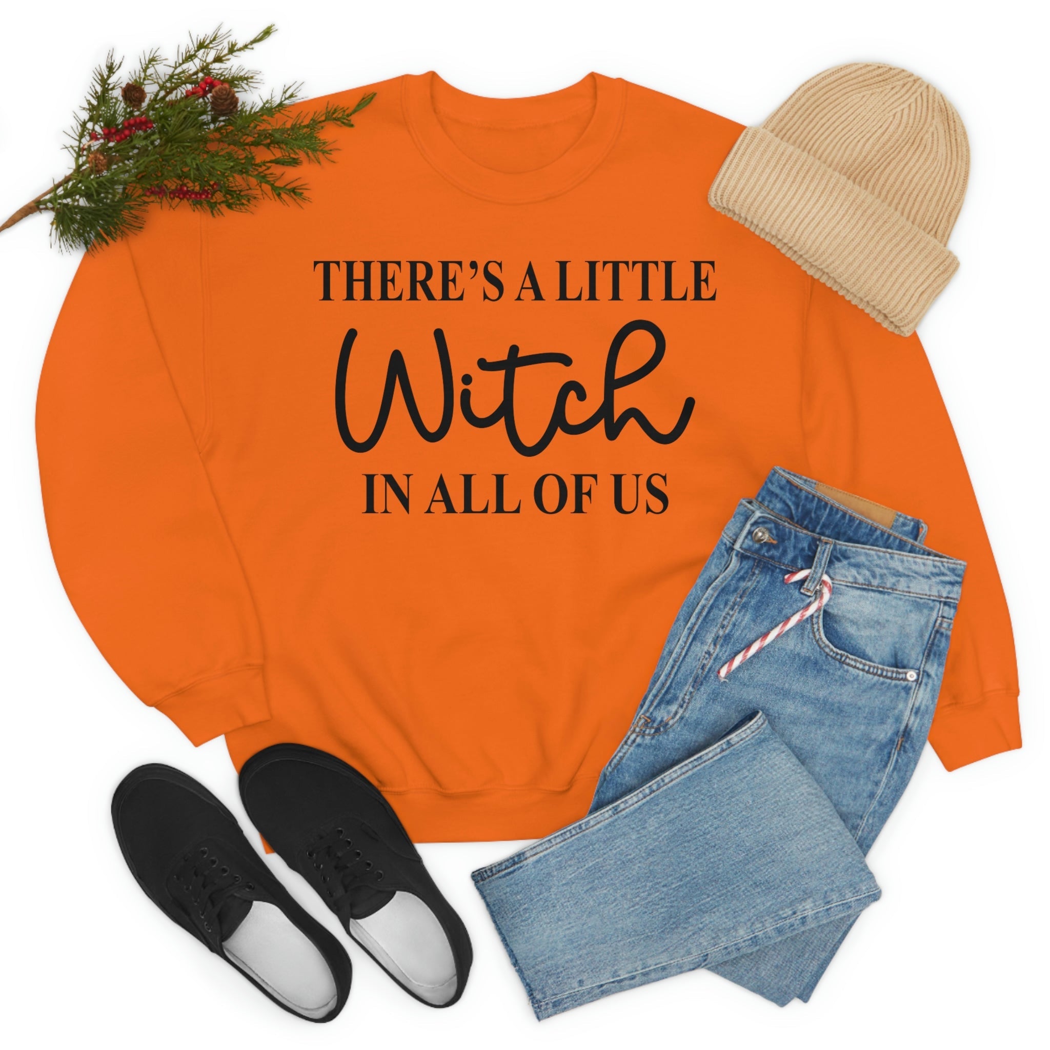 A stylish black t-shirt featuring the phrase 'There's A Little Witch In All Of Us' in a whimsical font, showcasing its soft fabric and durable stitching.