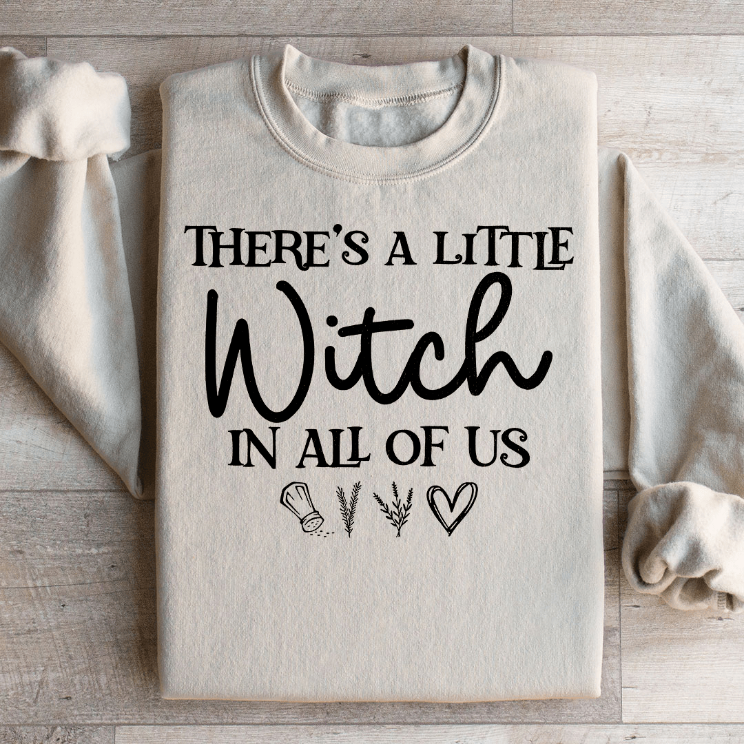 A stylish black t-shirt featuring the phrase 'There's A Little Witch In All Of Us' in a whimsical font, showcasing its soft fabric and durable stitching.