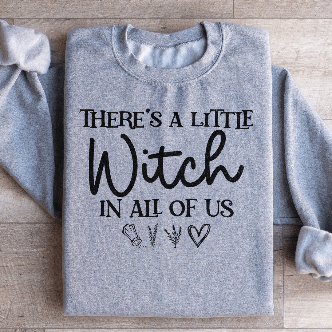 A stylish black t-shirt featuring the phrase 'There's A Little Witch In All Of Us' in a whimsical font, showcasing its soft fabric and durable stitching.