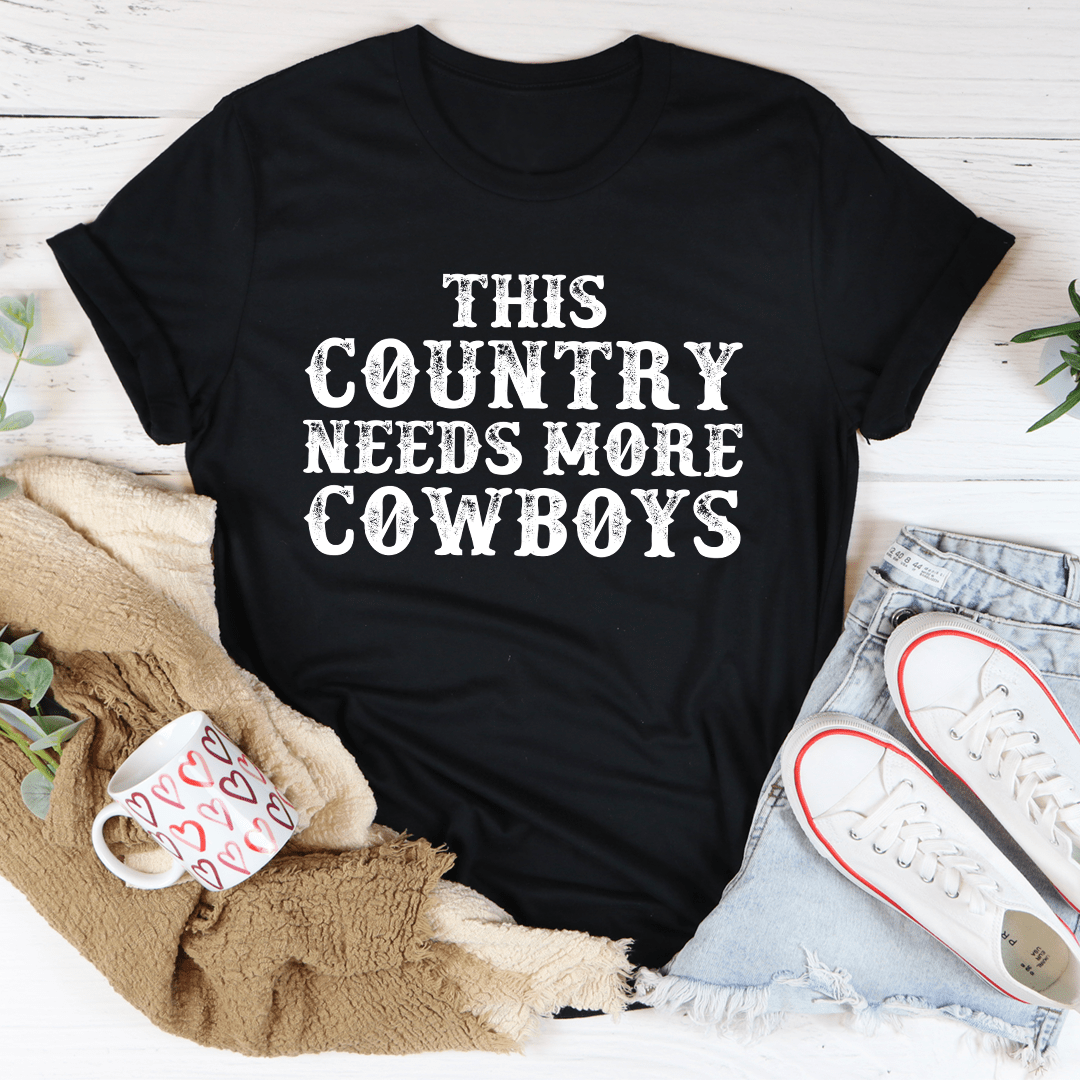 This Country Needs More Cowboys Tee featuring a bold cowboy-themed print on a soft, durable cotton fabric.