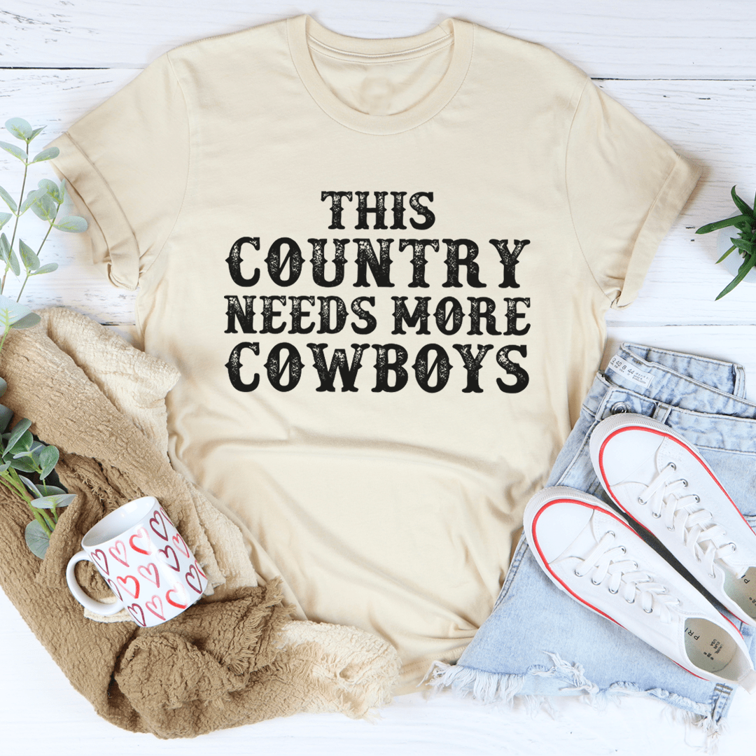 This Country Needs More Cowboys Tee featuring a bold cowboy-themed print on a soft, durable cotton fabric.