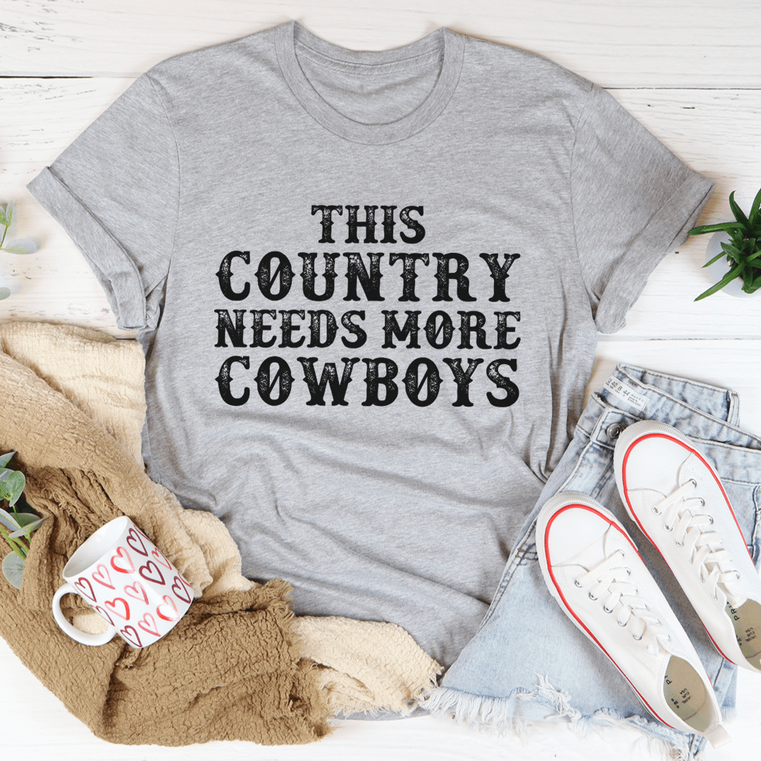 This Country Needs More Cowboys Tee featuring a bold cowboy-themed print on a soft, durable cotton fabric.