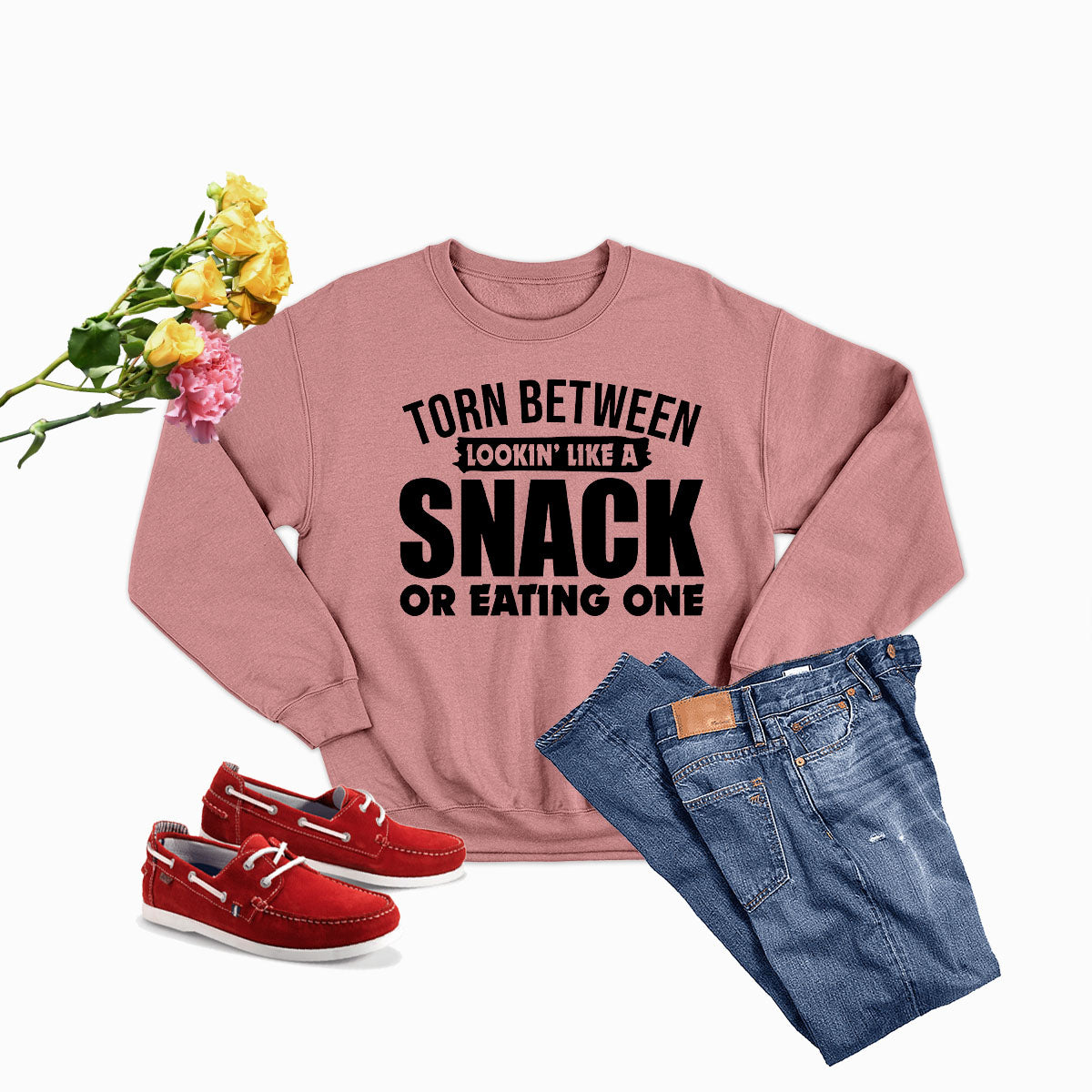 A cozy sweatshirt featuring the phrase 'Torn Between Lookin Like A Snack Or Eating One', made from soft ring-spun cotton with double stitching.