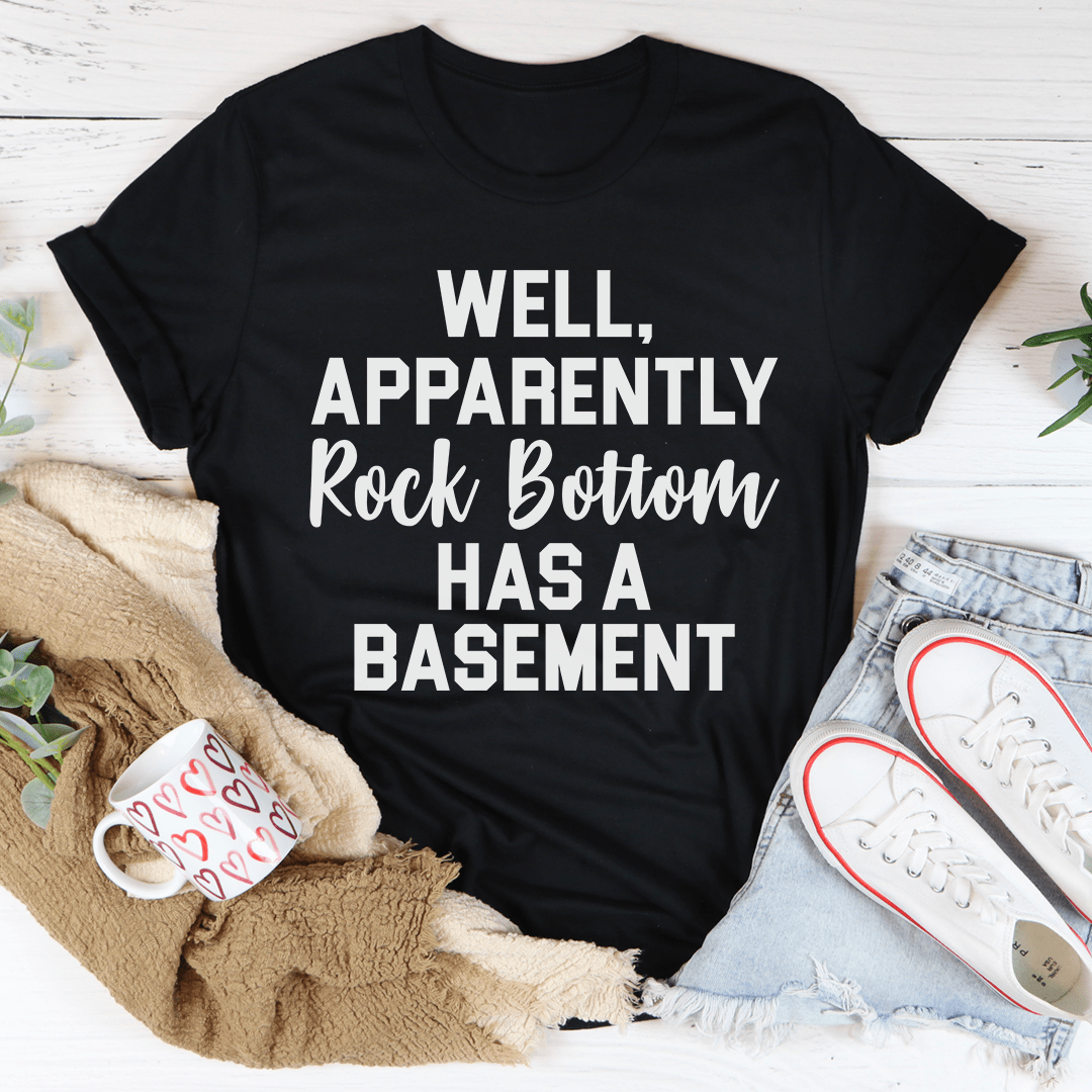 A stylish t-shirt featuring the phrase 'Well Apparently Rock Bottom Has A Basement', made from soft ring-spun cotton with double stitching.