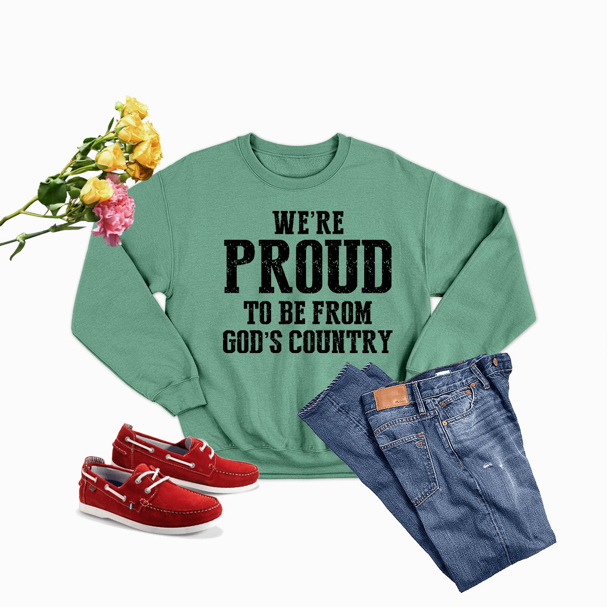 A cozy sweatshirt featuring the phrase 'We're Proud To Be From God's Country', made from a soft cotton/poly fleece blend.