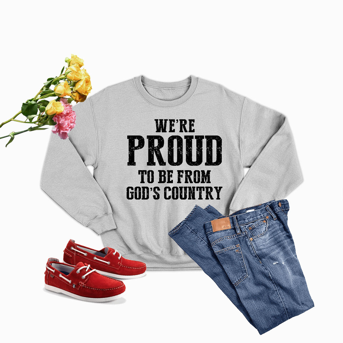 A cozy sweatshirt featuring the phrase 'We're Proud To Be From God's Country', made from a soft cotton/poly fleece blend.