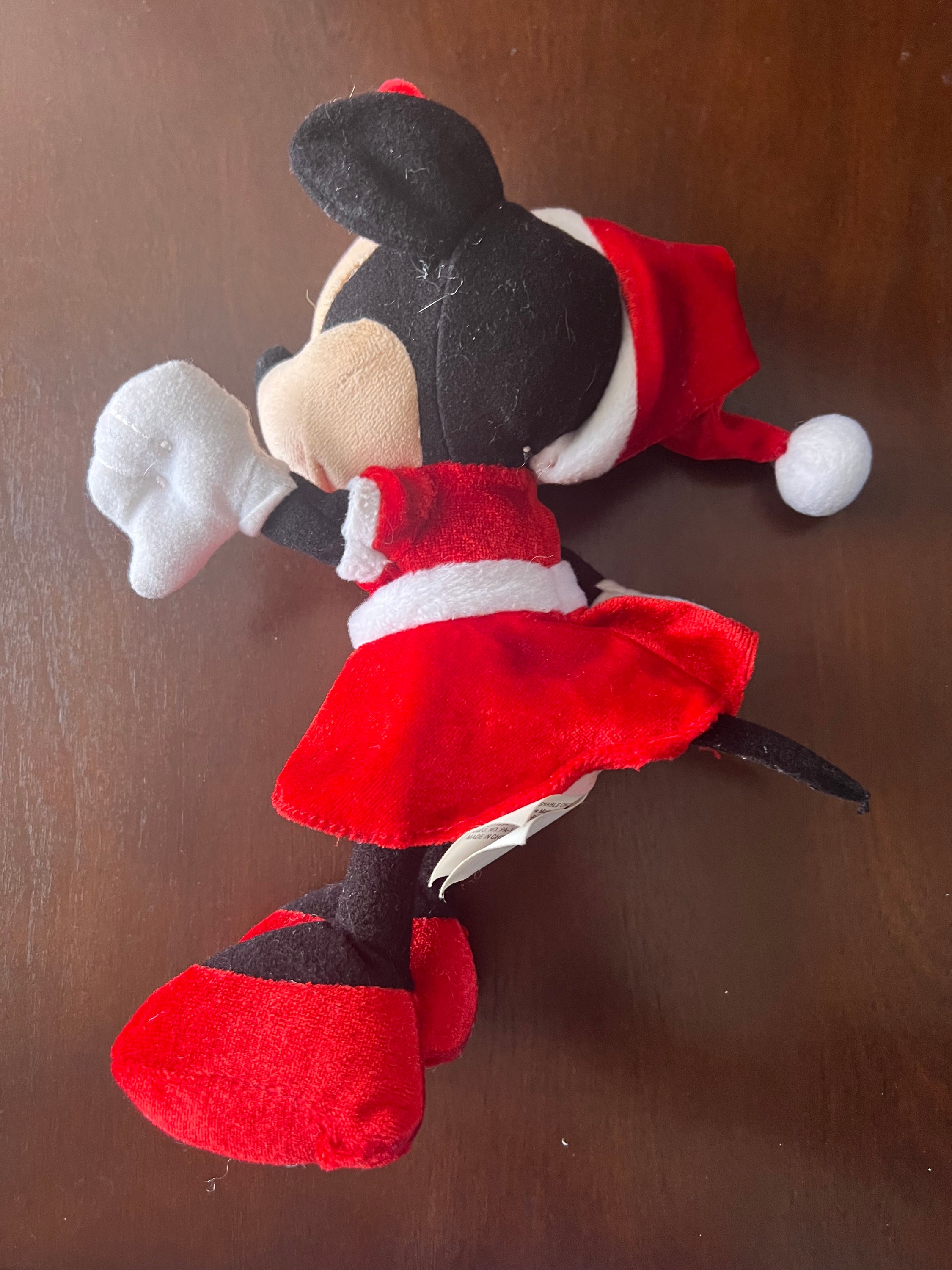 Disney Minnie Mouse plush toy wearing a festive Santa hat and red velvet dress, perfect for holiday celebrations.