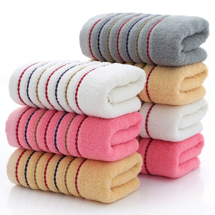 A set of luxurious 100% cotton striped towels in vibrant colors, showcasing their soft texture and stylish design.