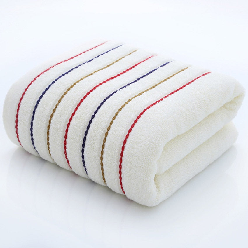 A set of luxurious 100% cotton striped towels in vibrant colors, showcasing their soft texture and stylish design.