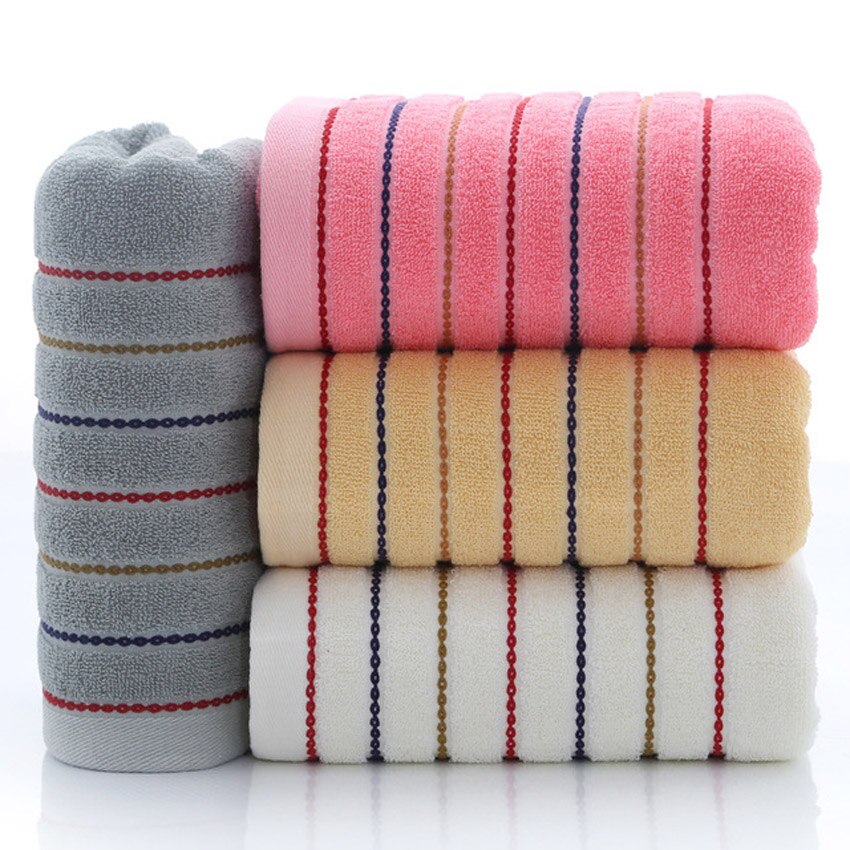 A set of luxurious 100% cotton striped towels in vibrant colors, showcasing their soft texture and stylish design.