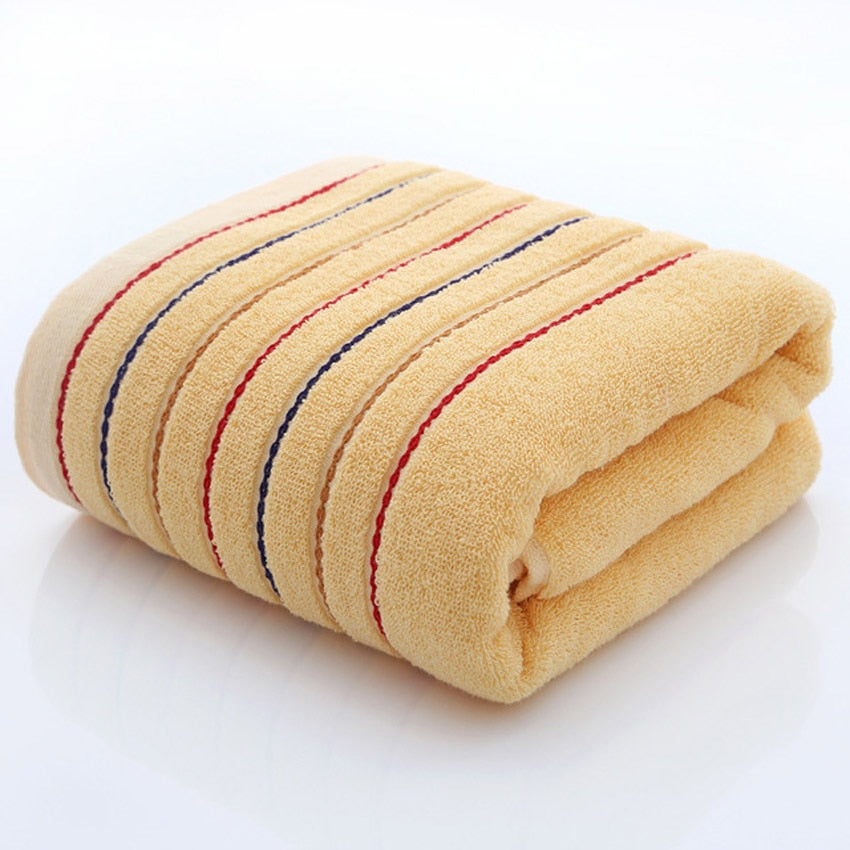 A set of luxurious 100% cotton striped towels in vibrant colors, showcasing their soft texture and stylish design.