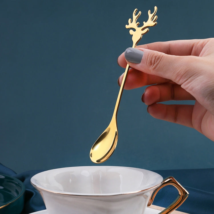 Two Christmas-themed stainless steel stirring spoons with deer design, perfect for holiday beverages.