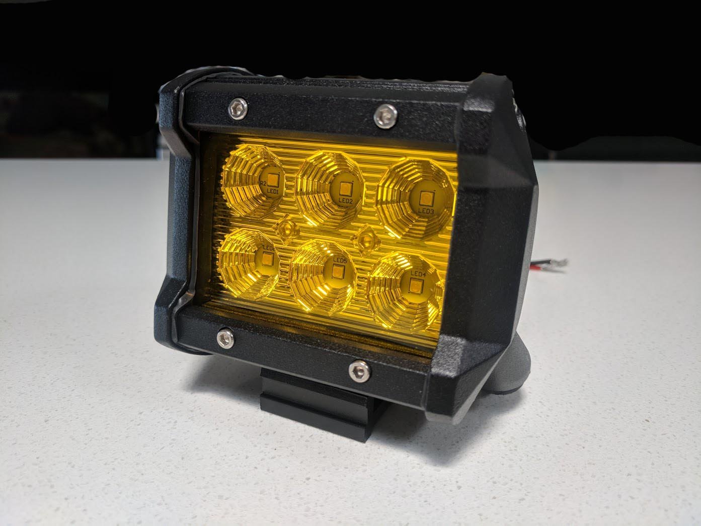 Two 4-inch flood LED light bars mounted on a truck, showcasing their bright yellow light and durable design.