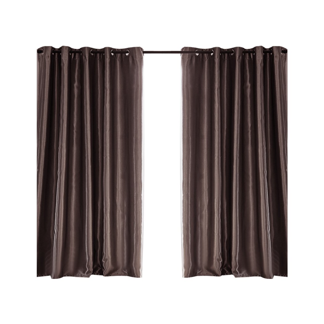 Elegant taupe 2X blockout curtains hanging in a bedroom, showcasing their luxurious texture and design.