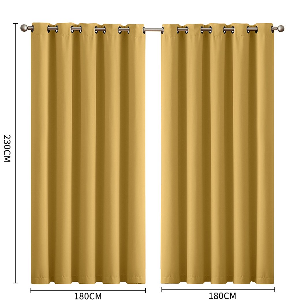 Two elegant blockout curtain panels in vibrant color, featuring eyelet design and triple weave fabric, hanging in a stylish room.