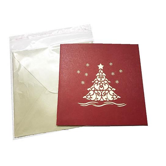 A vibrant 3D pop-up Christmas tree greeting card featuring colorful ornaments and a star, packaged with a red envelope.