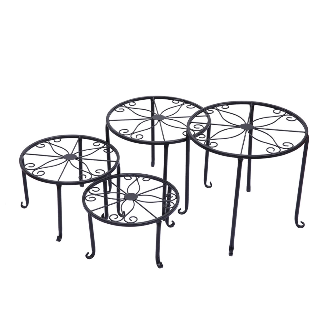 Four black metal plant stands arranged with various flower pots, showcasing an elegant outdoor and indoor decor.