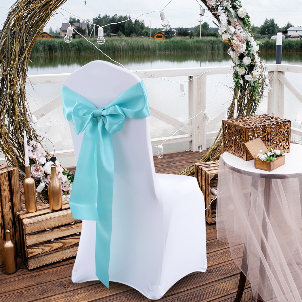 50 satin chair sashes in various colors, elegantly draped over chairs for event decoration.