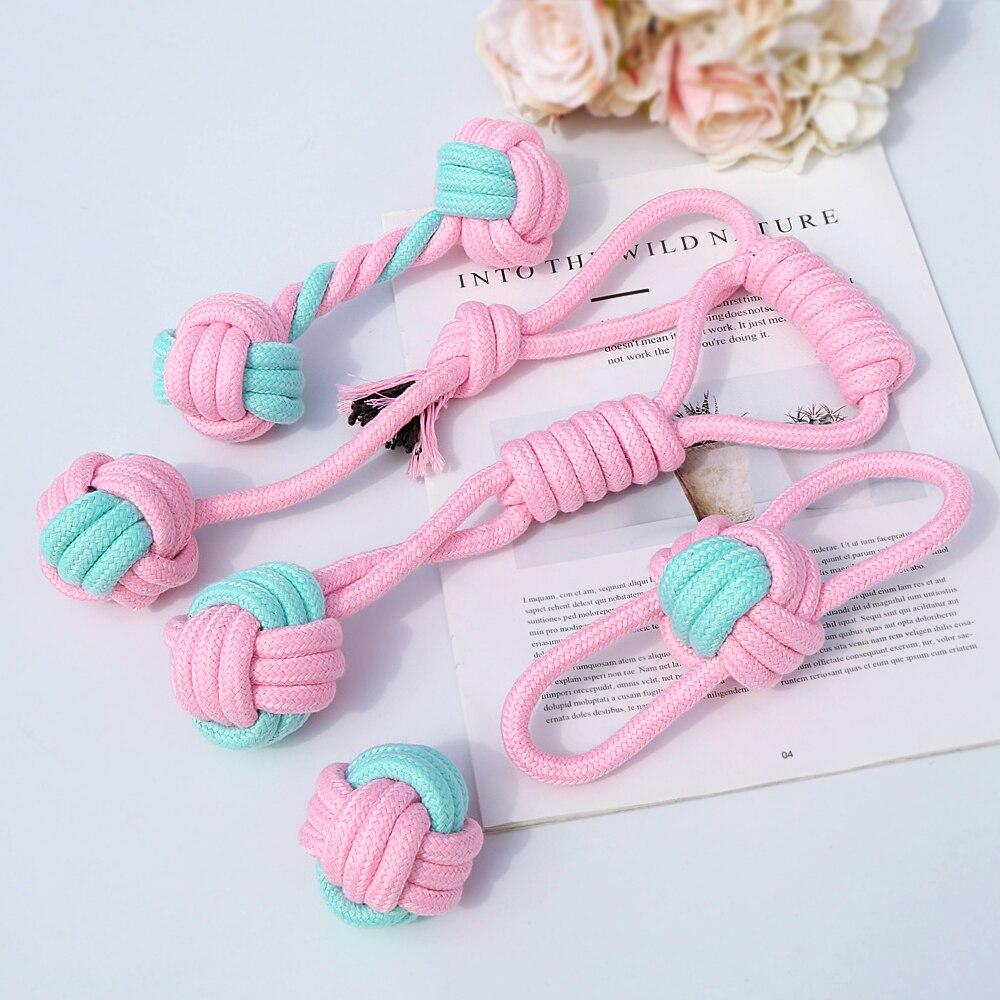 Five colorful cotton rope toys for dogs, designed for chewing and dental cleaning, featuring knots and a vibrant pink color.