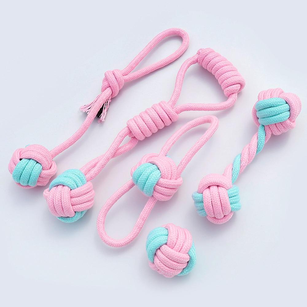 Five colorful cotton rope toys for dogs, designed for chewing and dental cleaning, featuring knots and a vibrant pink color.