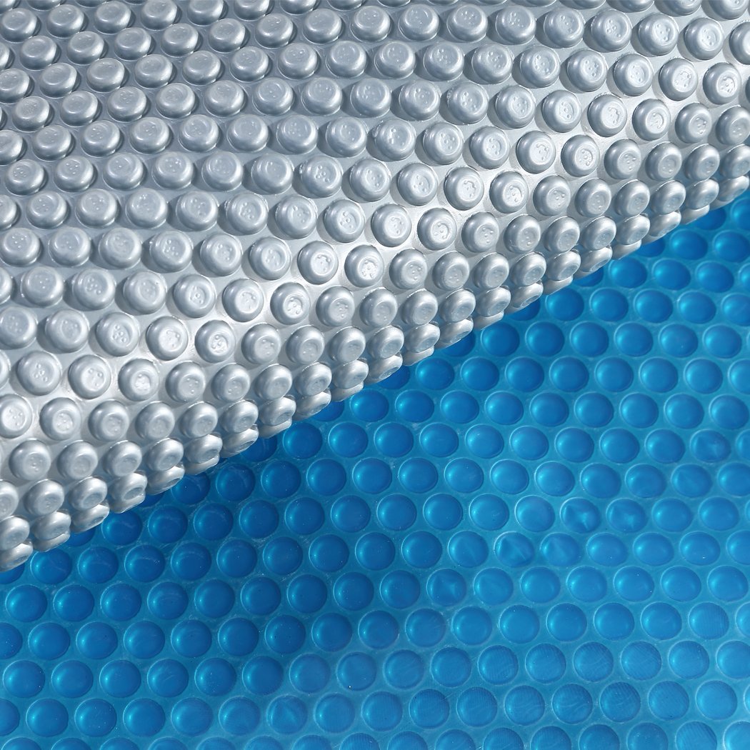 7x4M Real 400 Micron Solar Swimming Pool Cover with blue top and silver bottom, designed for durability and heat retention.