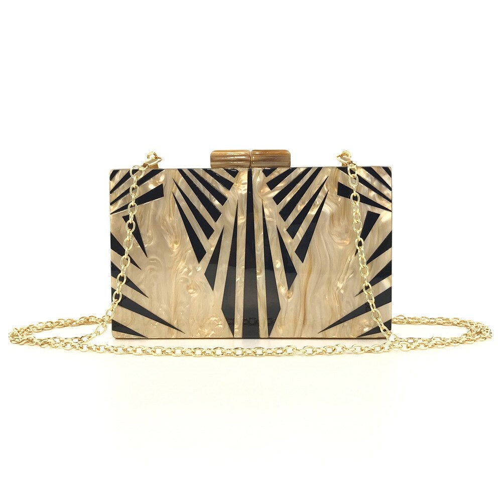 Acrylic luxury evening bag with a golden metal chain shoulder strap, featuring a stylish striped pattern and flap design.