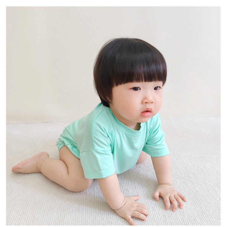 Baby unisex solid color rompers in various colors including pink, blue, green, and yellow, made from soft cotton blend fabric.