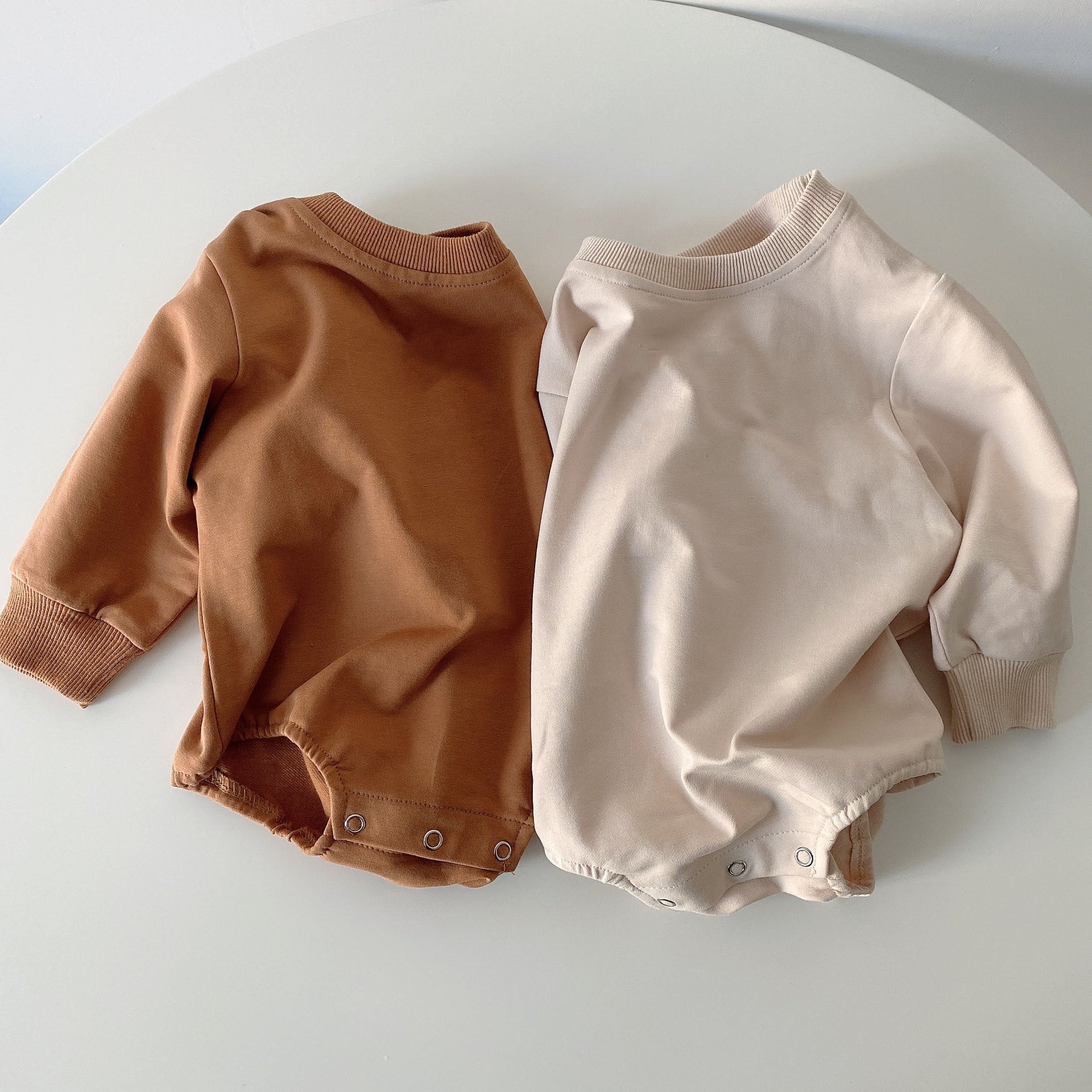 Baby unisex solid color rompers in beige and coffee, made from a soft cotton blend, suitable for boys and girls aged 3-18 months.