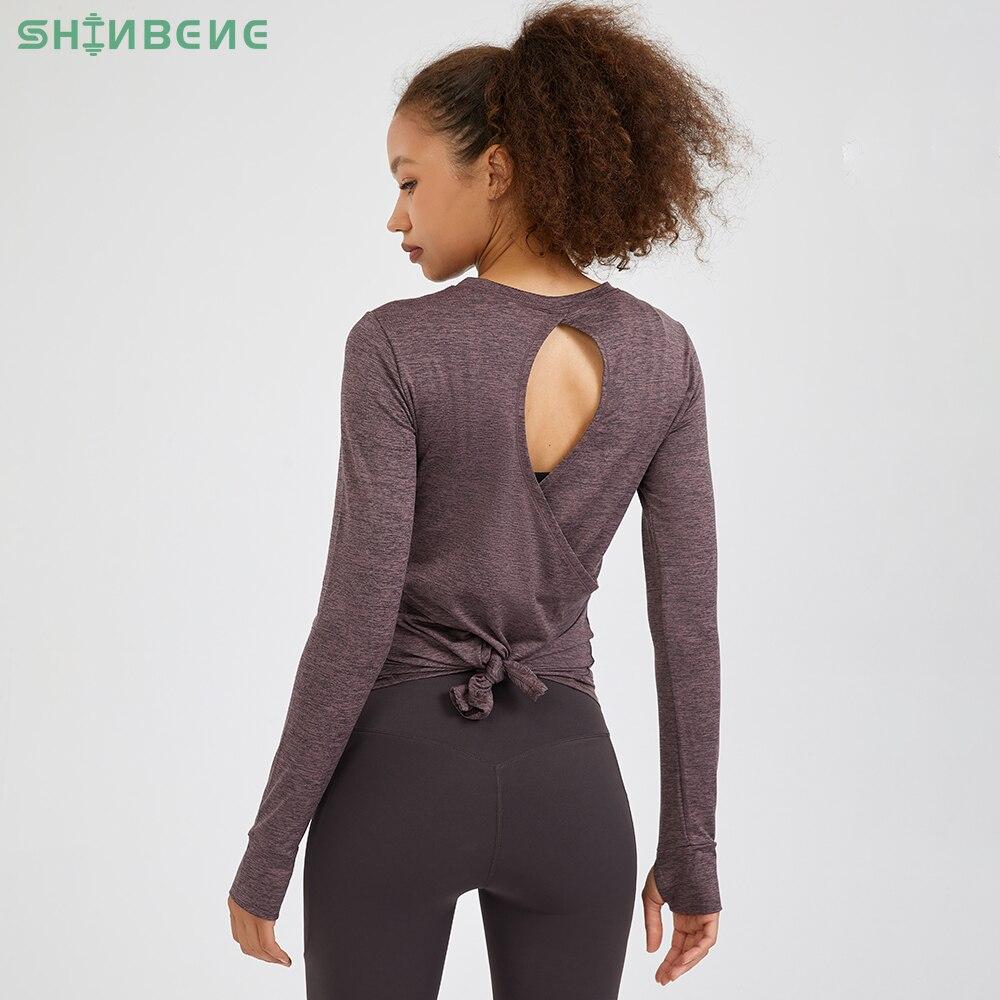 A stylish back open long sleeve training fitness yoga shirt for women, featuring a crew neck and thumb holes, perfect for workouts.