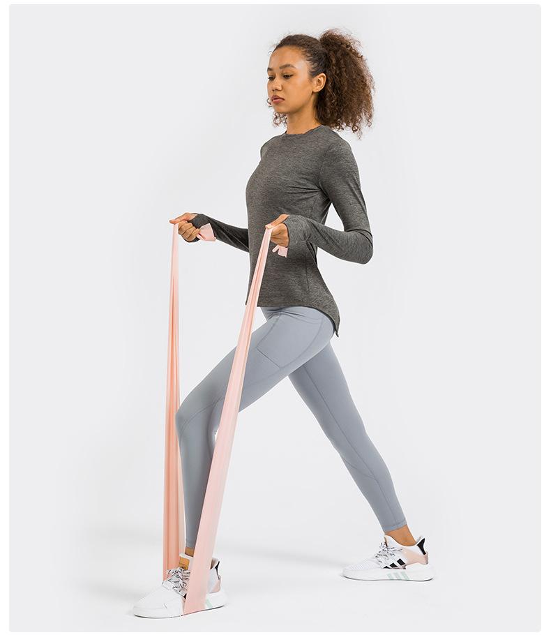 A stylish back open long sleeve training fitness yoga shirt for women, featuring a crew neck and thumb holes, perfect for workouts.