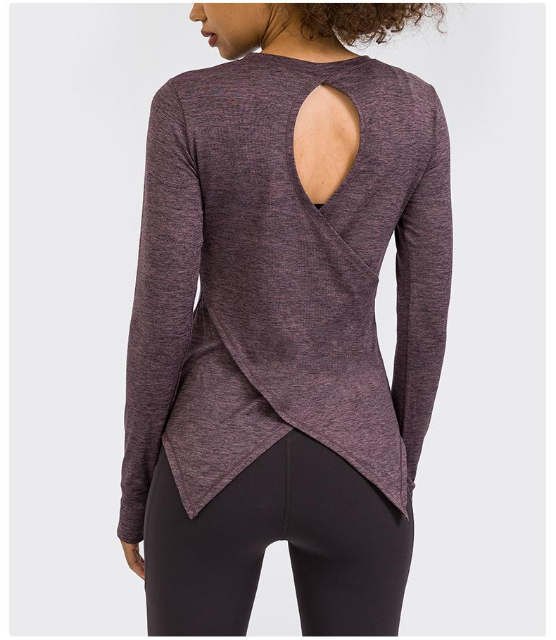 A stylish back open long sleeve training fitness yoga shirt for women, featuring a crew neck and thumb holes, perfect for workouts.