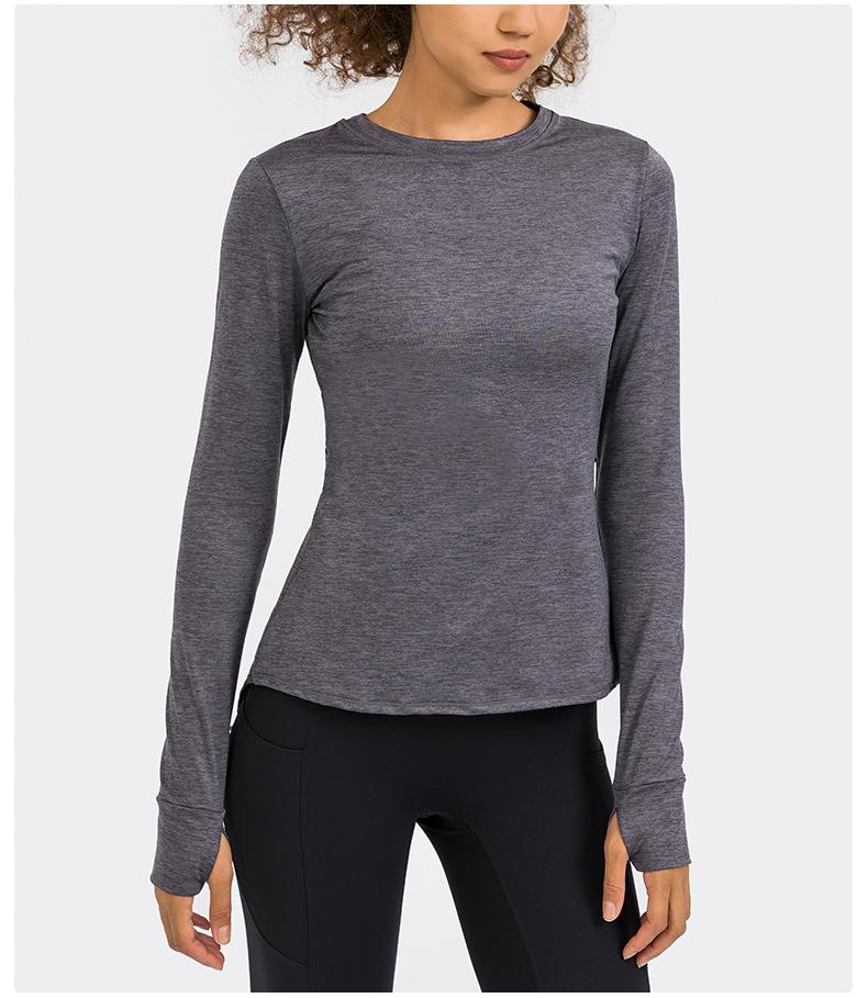 A stylish back open long sleeve training fitness yoga shirt for women, featuring a crew neck and thumb holes, perfect for workouts.