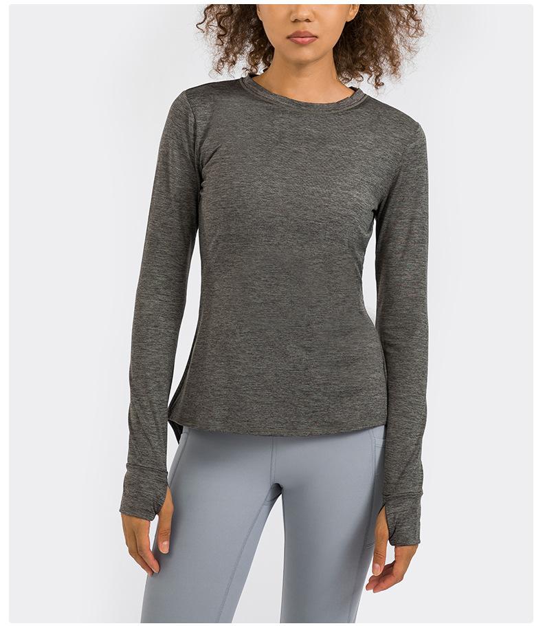 A stylish back open long sleeve training fitness yoga shirt for women, featuring a crew neck and thumb holes, perfect for workouts.