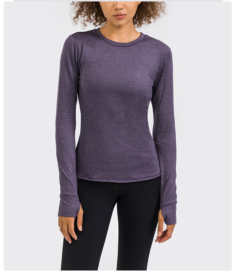 A stylish back open long sleeve training fitness yoga shirt for women, featuring a crew neck and thumb holes, perfect for workouts.