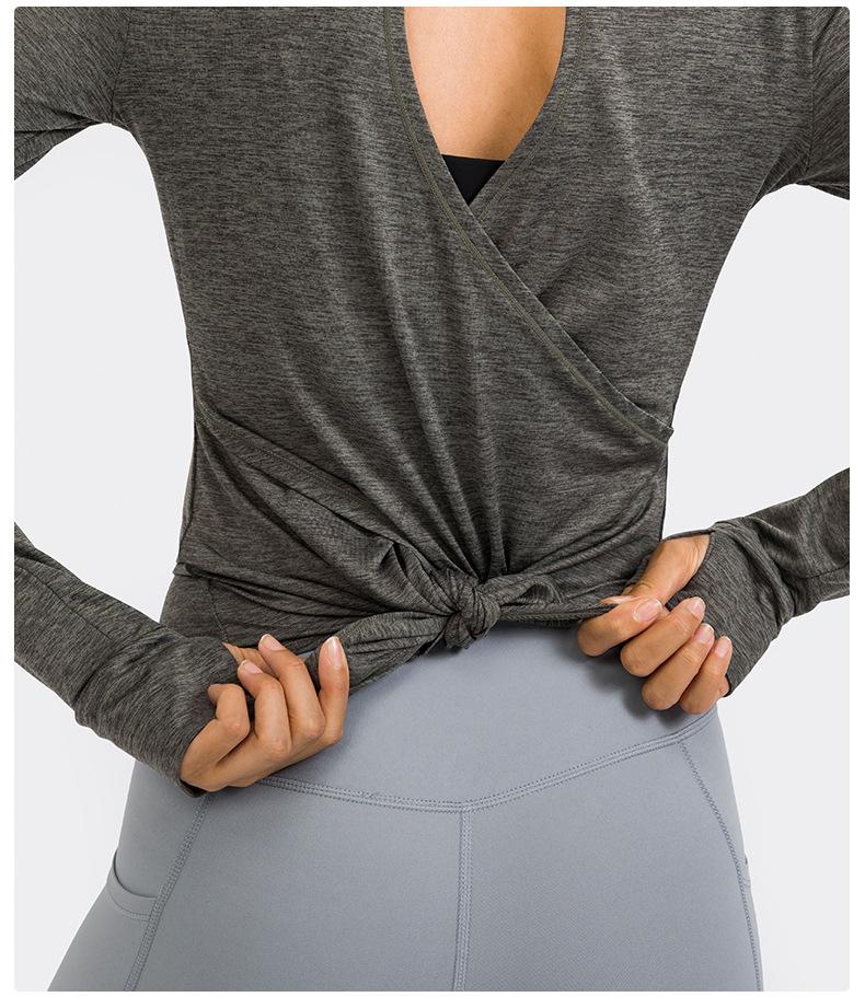 A stylish back open long sleeve training fitness yoga shirt for women, featuring a crew neck and thumb holes, perfect for workouts.